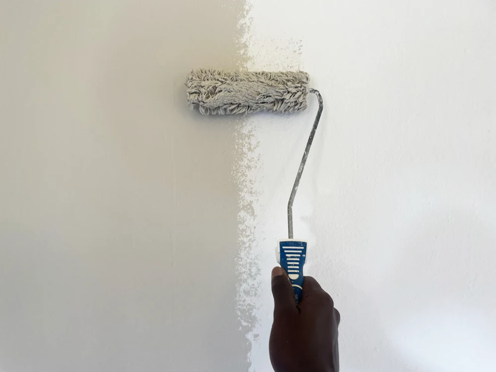 Rouleau de peinture sur un mur blanc